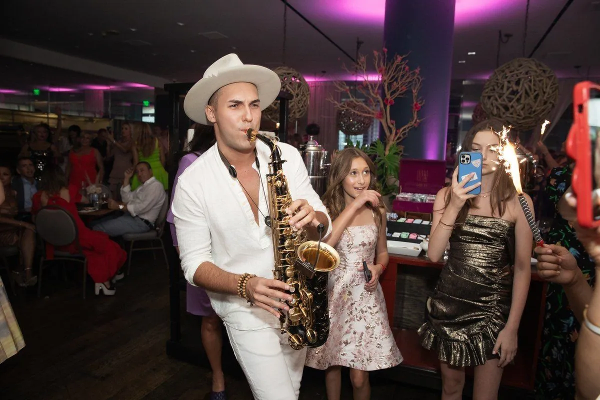 Saxophonist and guests with sparklers at a private celebration