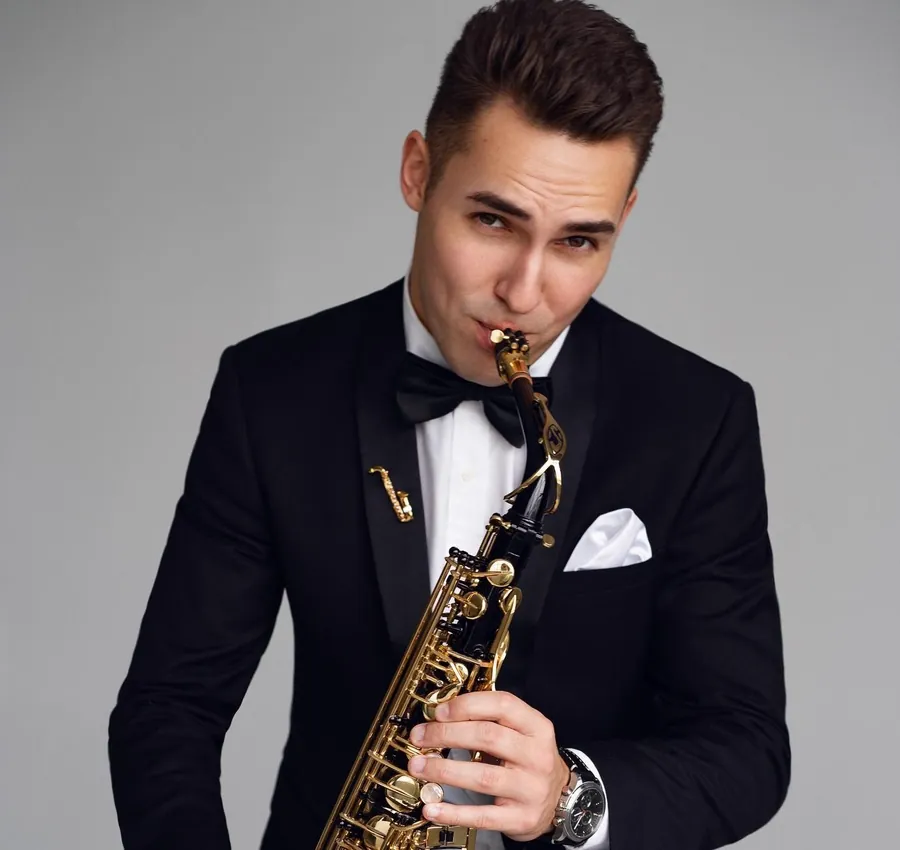 DJ ART with his saxophone in a tuxedo