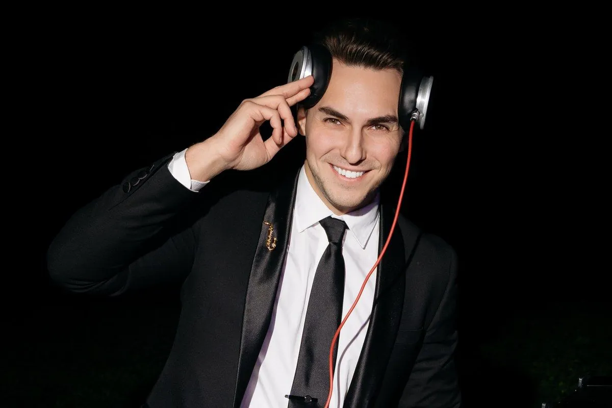 DJ ART in a black suit with headphones